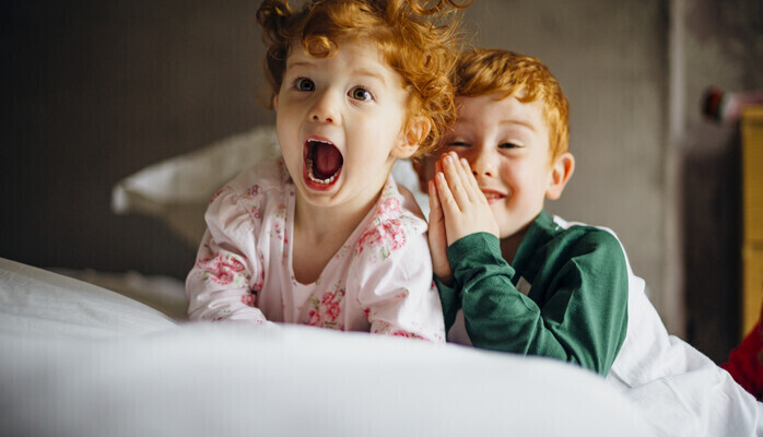 Barn i femårsåldern som läser bok med sin förälder