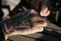 Handmodell med tatueringar skes till pizzareklam