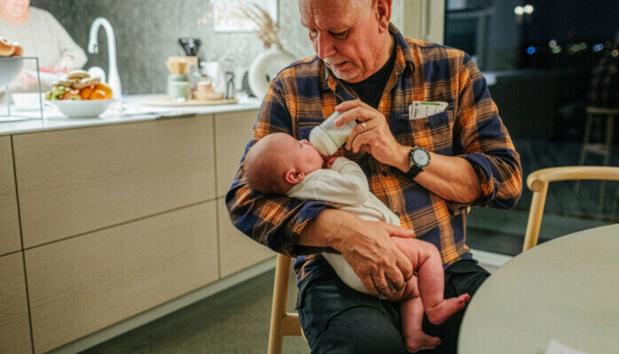 Morfar/farfar och bebis 2-6 månader för reklamfotografering