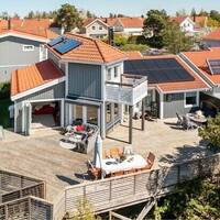 hus med stor altan och utsikt över skog